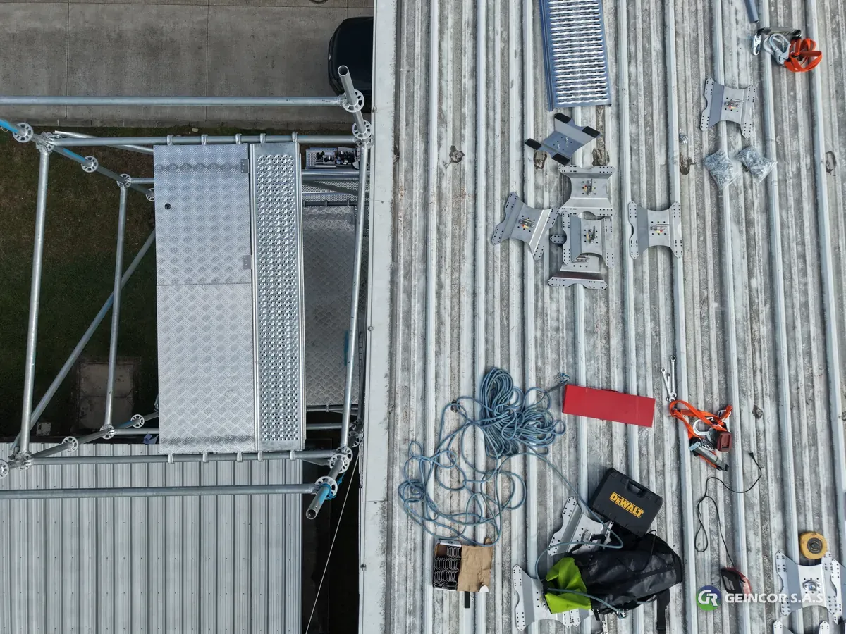 Vista cenital del kit de trabajo sobre la cubierta: cuerdas, arnés, herramientas y andamio de acceso.