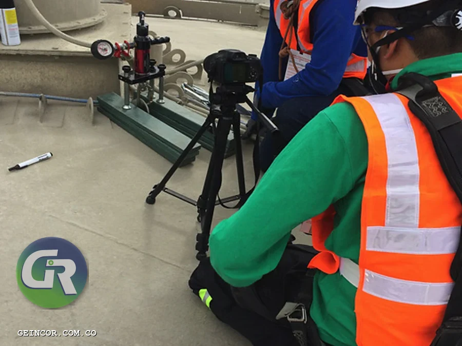 Dos técnicos con chaleco reflectivo revisando equipos de protección contra caídas durante la inspección anual.